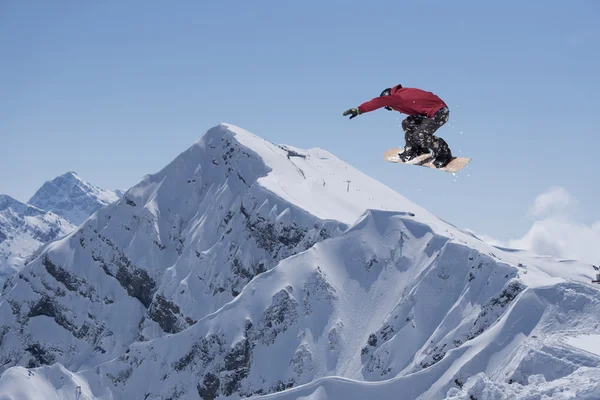 Um snowboarder voador nas montanhas. Desporto extremo. — Fotografia de Stock