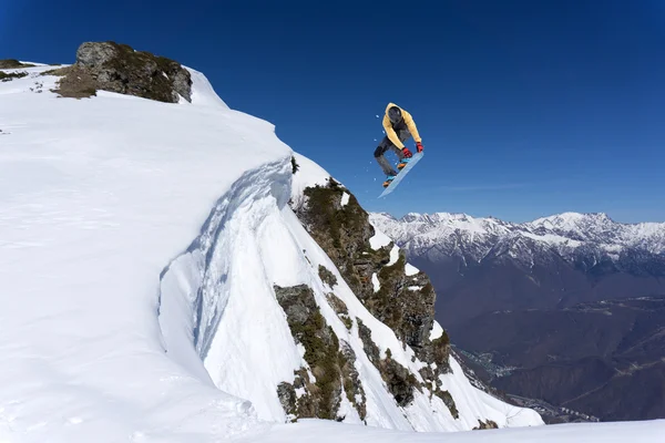 Um snowboarder voador nas montanhas. Desporto extremo. — Fotografia de Stock