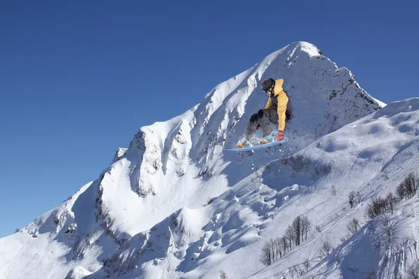 Volando snowboarder en las montañas. Deporte extremo. —  Fotos de Stock