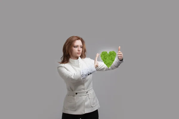 Mulher segurando verde planta coração em suas mãos — Fotografia de Stock