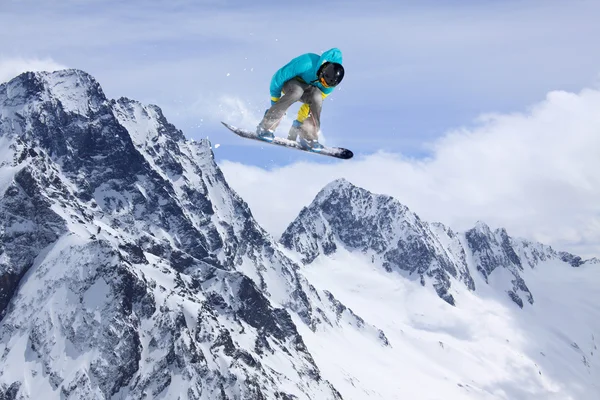 Um snowboarder voador nas montanhas. Desporto extremo. — Fotografia de Stock