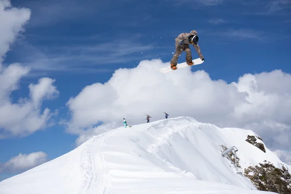 Flygande snowboardåkare på fjället. Extrem sport. — Stockfoto