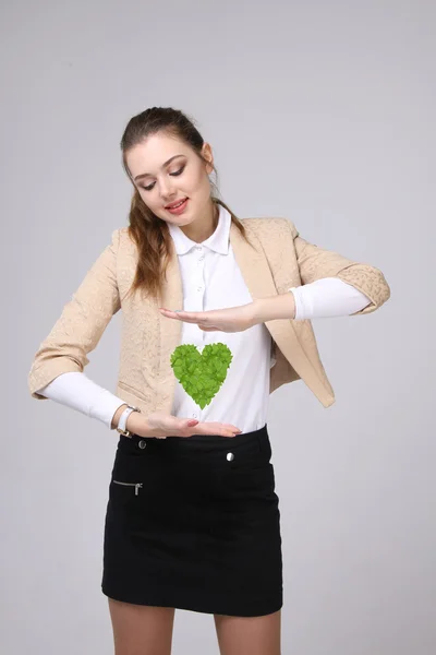 她手里拿着绿色的植物心的女人 — 图库照片