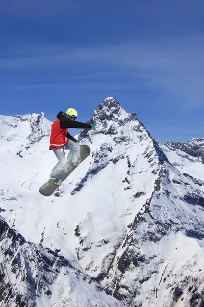 Fliegender Snowboarder auf den Bergen. Extremsport. — Stockfoto