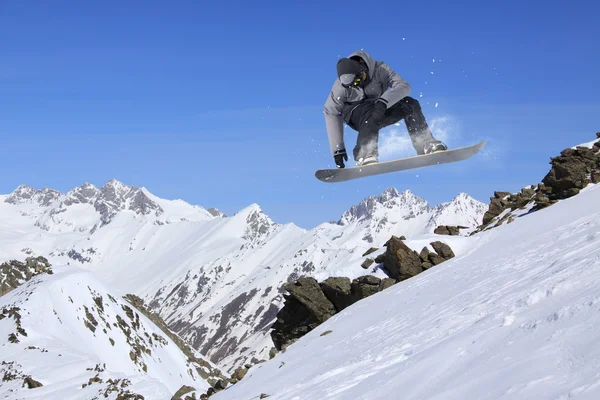 Repülő snowboardos a hegyekben. Extrém sport. — Stock Fotó