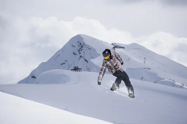 Um snowboarder voador nas montanhas. Desporto extremo. — Fotografia de Stock