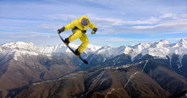 Snowboarder άλμα στα βουνά. Εξτριμ σπορ. — Φωτογραφία Αρχείου