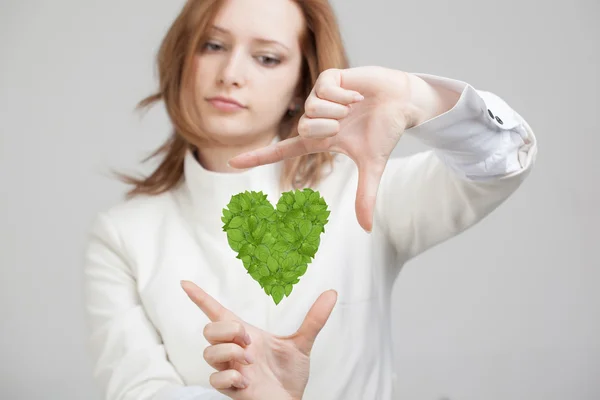 Mujer sosteniendo corazón de planta verde en sus manos — Foto de Stock