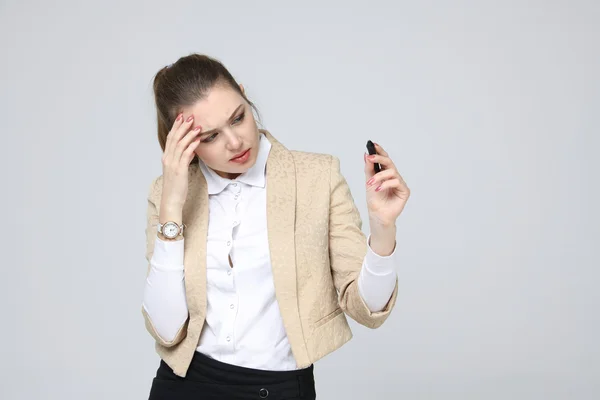 Junge Frau mit Stift auf grauem Hintergrund — Stockfoto