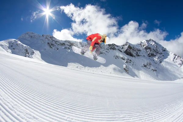 Maken van springen, extreme berg freeride snowboarder. — Stockfoto