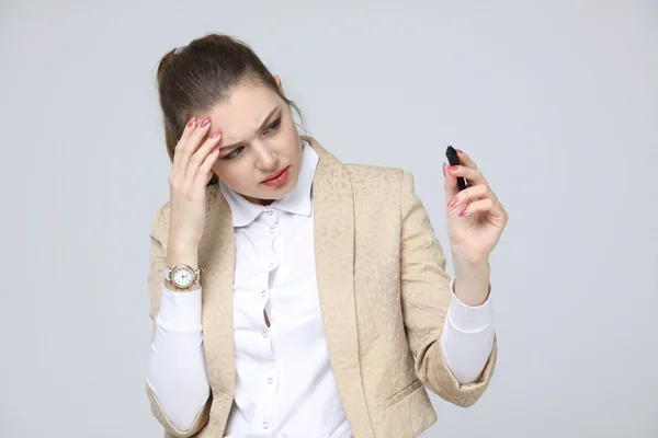 Jeune femme avec stylo sur fond gris — Photo