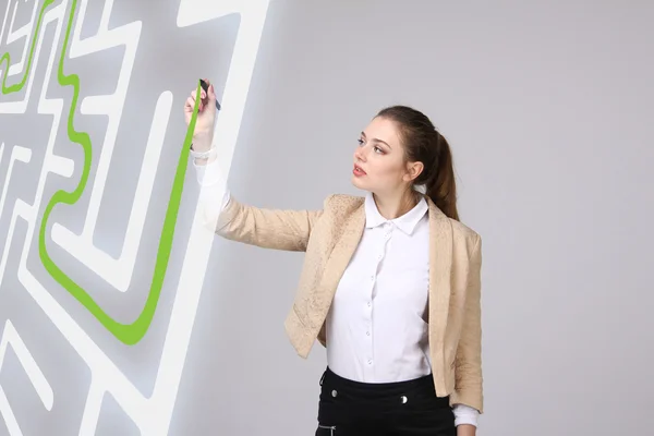 Jovem mulher encontrar a solução labirinto, escrevendo no quadro branco . — Fotografia de Stock