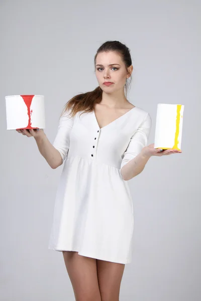 Fată în rochie albă care deține cutii de vopsea — Fotografie, imagine de stoc