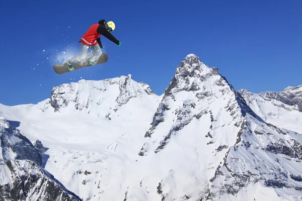 Snowboarder saltando sobre montañas. Deporte extremo . — Foto de Stock