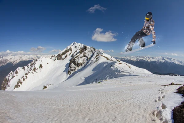 Snowboardåkare hoppa på bergen. Extrem sport. — Stockfoto