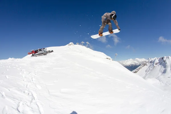 Snowboarder, ugrás a hegyekben. Extrém sport. — Stock Fotó