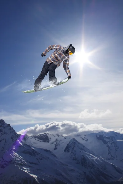 Um snowboarder voador nas montanhas. Desporto extremo. — Fotografia de Stock