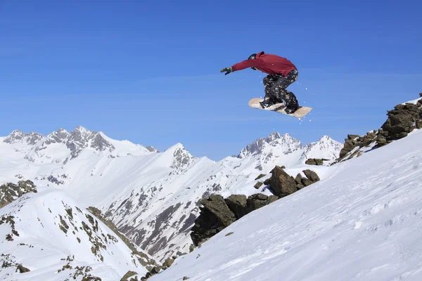 Um snowboarder voador nas montanhas. Desporto extremo. — Fotografia de Stock