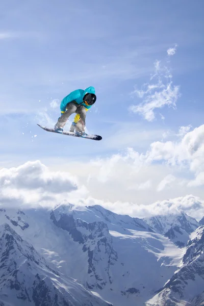 Um snowboarder voador nas montanhas. Desporto extremo. — Fotografia de Stock