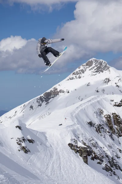 Fliegender Snowboarder auf den Bergen. Extremsport. — Stockfoto