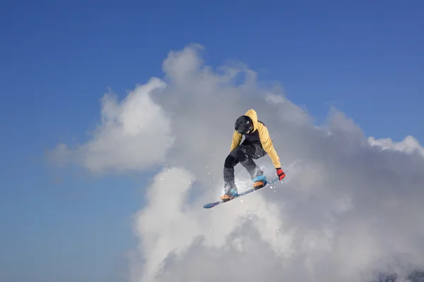 Um snowboarder voador nas montanhas. Desporto extremo. — Fotografia de Stock