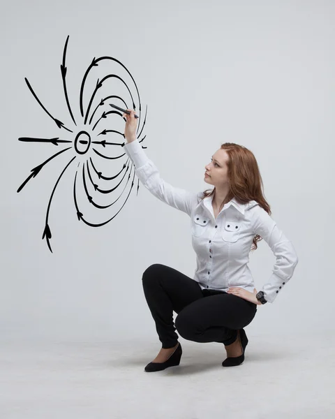 Mujer joven, profesora de física dibuja un diagrama del campo eléctrico — Foto de Stock