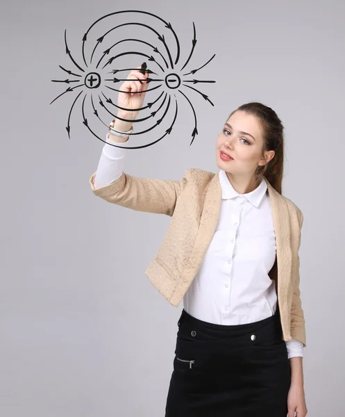 Jonge vrouw, natuurkunde leraar trekt een diagram van het elektrisch veld — Stockfoto