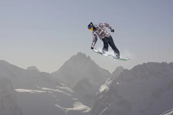 Snowboard ugrik a hegyek. Extrém téli sport. — Stock Fotó