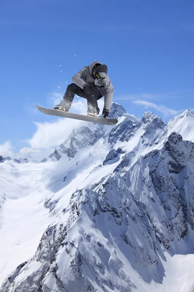 Salto in snowboard sulle montagne. Sport invernali estremi . — Foto Stock