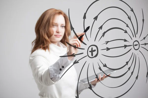 Junge Frau, Physiklehrerin zeichnet ein Diagramm des elektrischen Feldes — Stockfoto