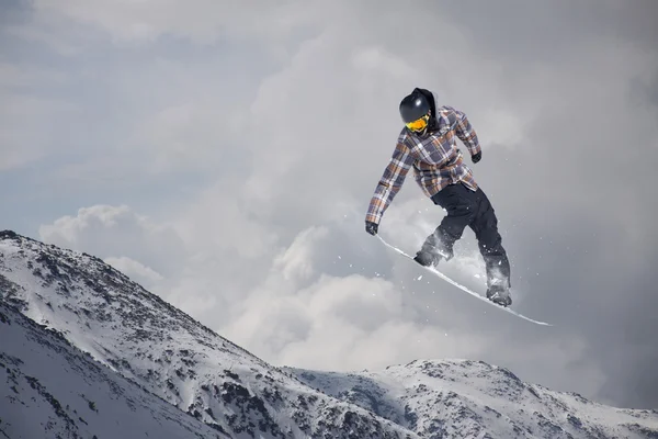 Snowboarder, ugrás a hegyekben. Extrém sport. — Stock Fotó