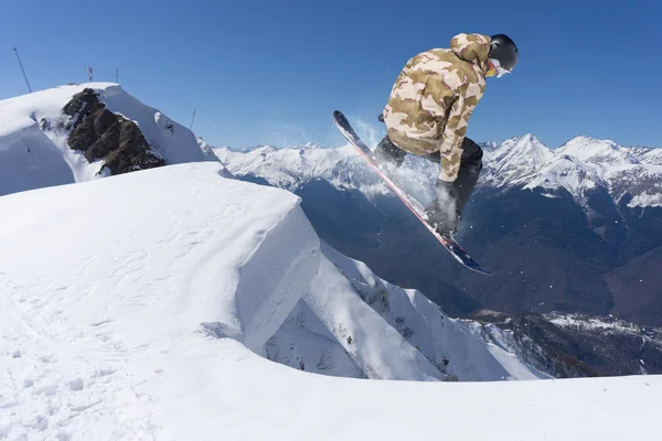 Snowboardåkare hoppa på bergen. Extrem sport. — Stockfoto