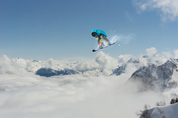 Um snowboarder voador nas montanhas. Desporto extremo. — Fotografia de Stock