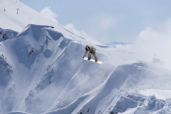 Fliegender Snowboarder auf den Bergen. Extremsport. — Stockfoto
