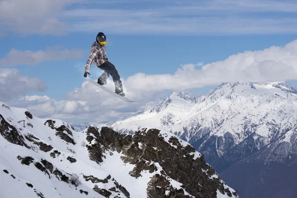 Flygande snowboardåkare på fjället. Extrem sport. — Stockfoto