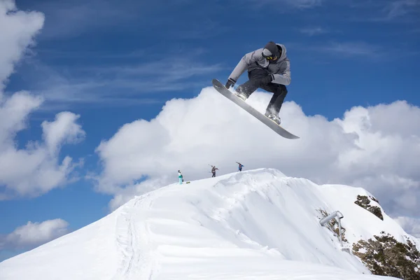 Flygande snowboardåkare på fjället. Extrem sport. — Stockfoto