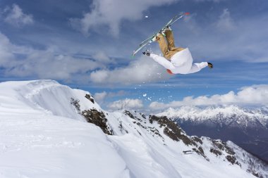 Ski rider jumping on mountains. Extreme ski freeride. clipart