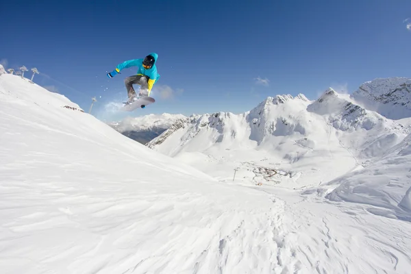 Cavaleiro de snowboard pulando em montanhas. Freerida extrema de snowboard . — Fotografia de Stock