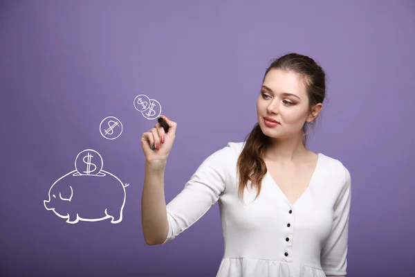 Junge Frau zeichnet ein Sparschwein — Stockfoto