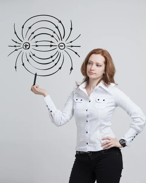 Junge Frau, Physiklehrerin zeichnet ein Diagramm des elektrischen Feldes — Stockfoto