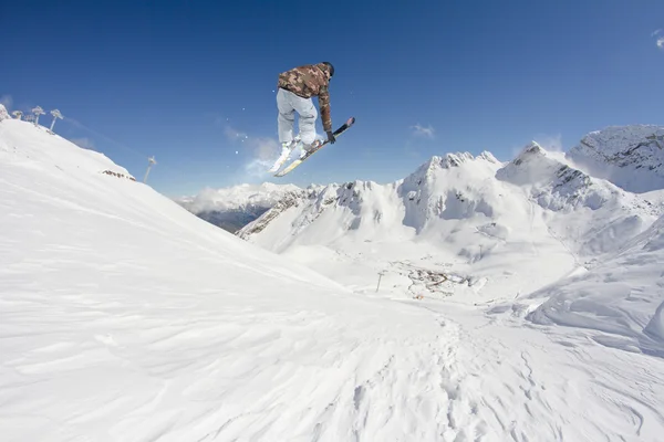 Cavaleiro de esqui a saltar sobre montanhas. Esporte de freeride de esqui extremo . — Fotografia de Stock