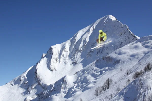 Lyžařské jezdec skákat na horách. Extrémní lyžařské freeride sport. — Stock fotografie