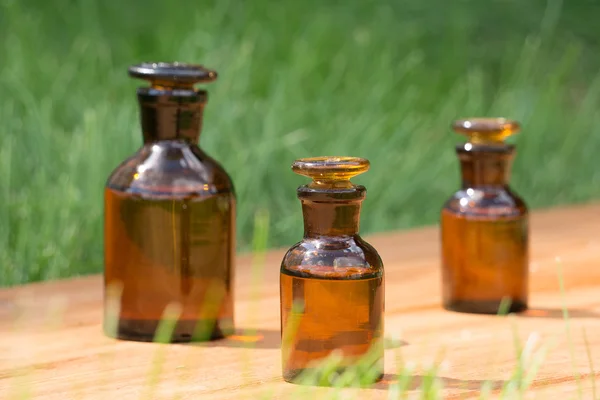 Pequeñas botellas marrones en booden tablero y hierba — Foto de Stock