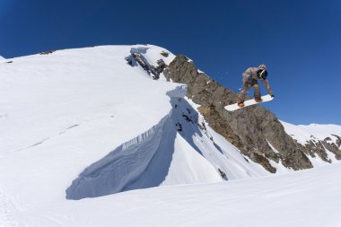 Dağlarda atlayan snowboard binicisi. Ekstrem snowboard serbest spor.