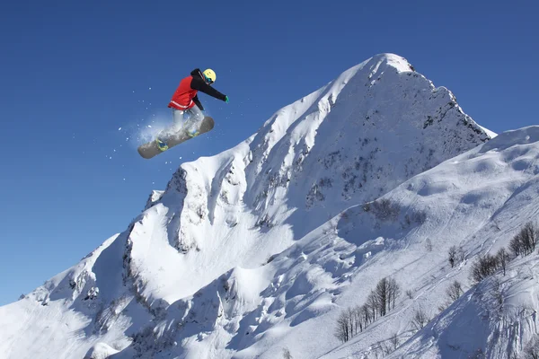 Snowboard rider saltando en las montañas. Extremo snowboard freeride sport. — Foto de Stock