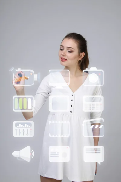 Woman pressing high tech type of modern multimedia buttons on a virtual background — Stock Photo, Image