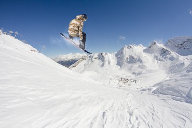 Dağlarda atlayan snowboard binicisi. Ekstrem snowboard serbest spor.