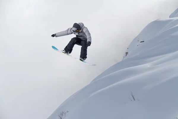 Snowboard rider saltando en las montañas. Extremo snowboard freeride sport. — Foto de Stock