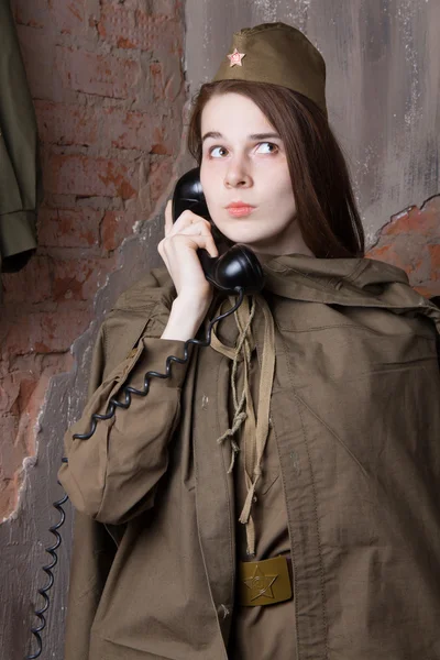 Žena v ruské vojenské uniformě mluví na telefonu. Voják žena během druhé světové války. — Stock fotografie