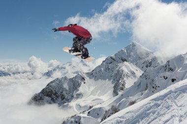 Dağlarda atlayan snowboard binicisi. Ekstrem snowboard serbest spor.